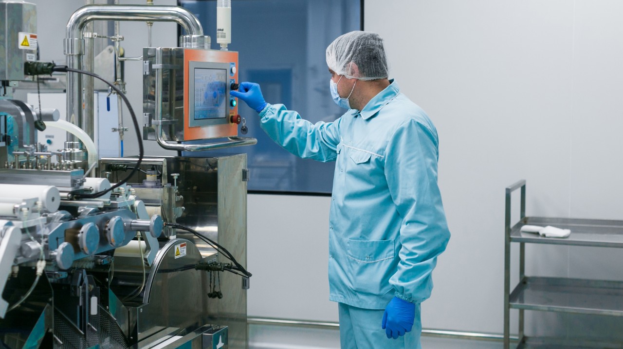 A worker in sterile clothing producing wound and skin care products.